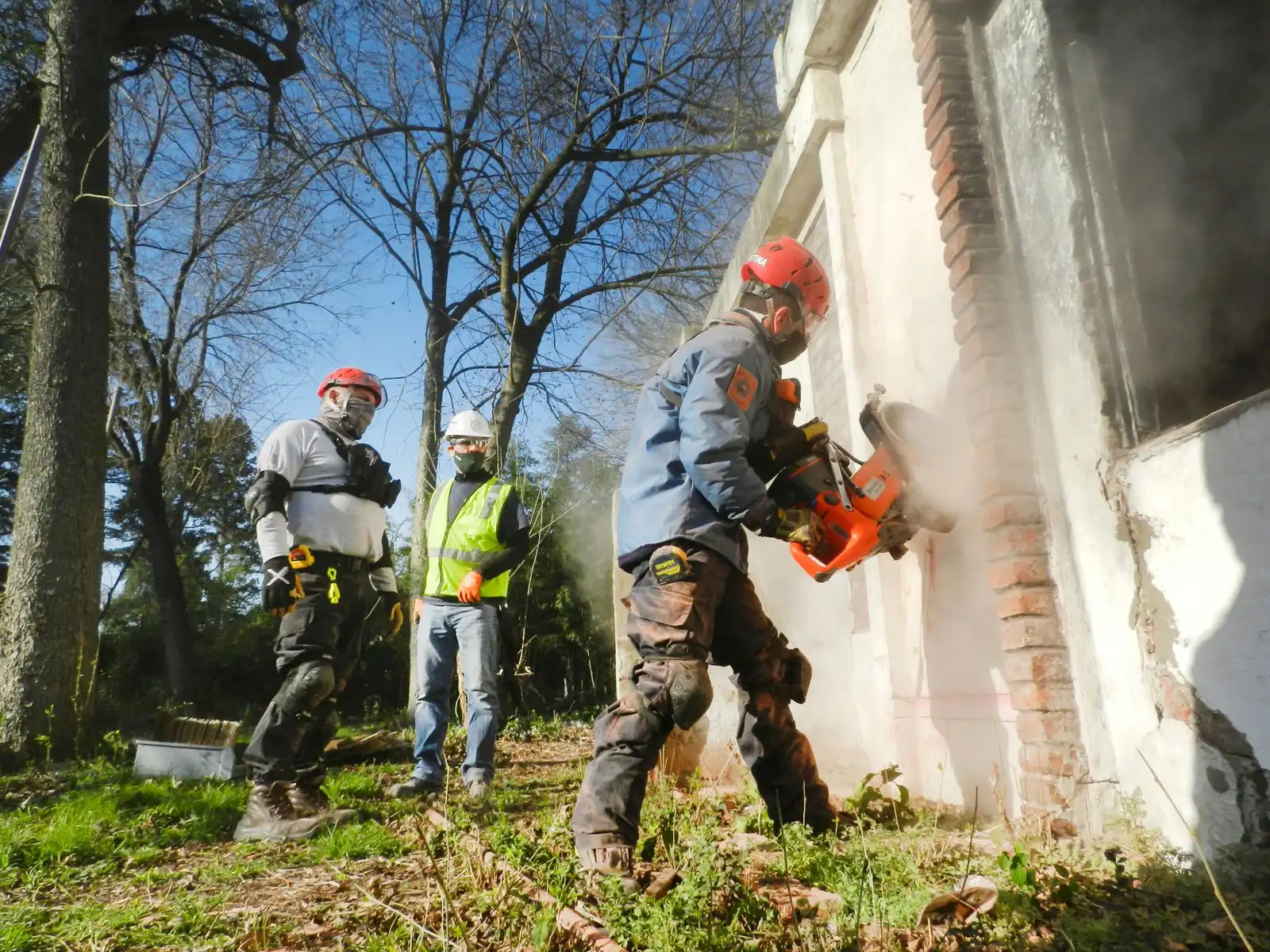 Asbestzement ausbauen in Coesfeld – Team in Schutzausrüstung trennt mit Schneidgerät asbestzementhaltige Bauteile