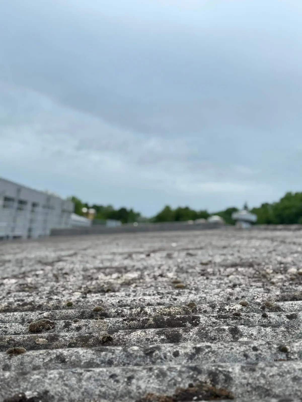Verwittertes Asbestzement-Wellplattendach an einem älteren Gebäude in NRW